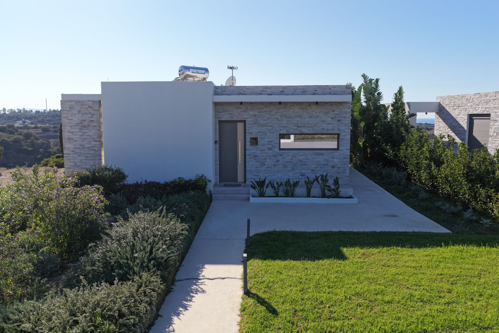 Villa Rosemary from the air: stone facade, lawn and entrance path