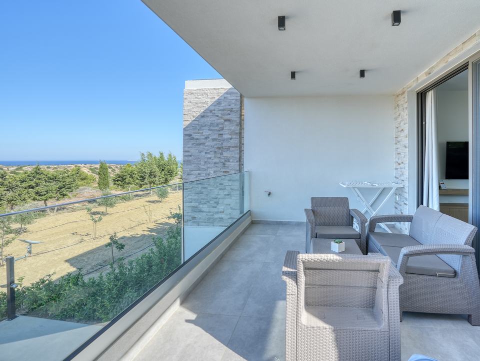 Elia's balcony with table and chairs, the sea on the horizon